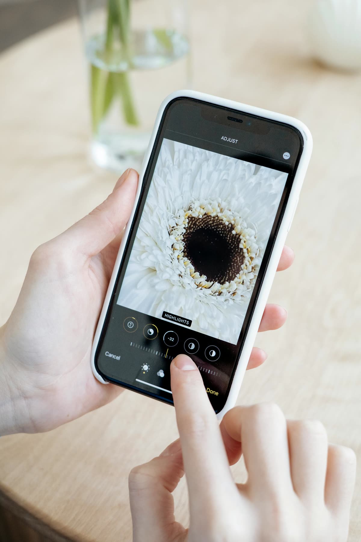 Hands editing a flower photo on a smartphone